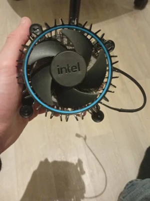 Intel CPU-kylare med kopparbas - Säljer en svart Intel CPU-kylare med fläkt och blå ring runt om. Kylflänsen har en kopparbas för bättre värmeavledning och svarta plastfästen för enkel montering. Perfekt för dig som vill kyla din processor effektivt.