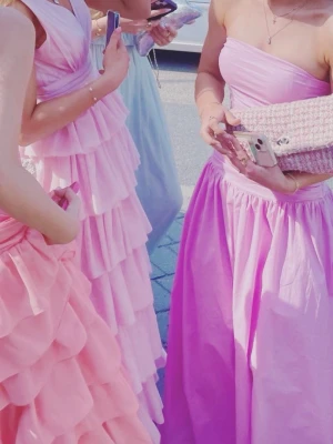 Ljusrosa balklänning  - Säljer en ljusrosa balklänning med axelbandslös design och figurnära överdel. Endast använd 1 gång och passar mig som är ca 160 cm! 