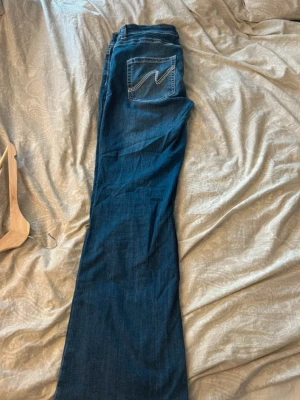 Mörkblå bootcut jeans från NELLY - Snygga mörkblå bootcut jeans från NELLY med fin och snygg design på bakfickan. Jeansen är låg midja och är tillverkade i mjuk denim med lite stretch för extra komfort. Jag stryker och tvättar de innan jag skickar de till dig! Storlek 44/46