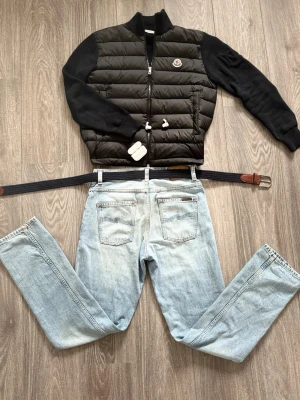 Svart cardiganjacka från Moncler - Pris kan diskuteras vid snabb köp!! Snygg svart cardiganjacka från Moncler med quiltad front och stickade ärmar. Jackan har dragkedja framtill, ribbade muddar och Moncler-logga på bröstet. Perfekt för dig som vill ha en stilren och exklusiv look.