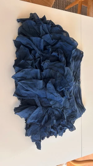 Blå volangkjol från Dondup - Supersnygg blå kjol från Dondup med flera lager volanger som ger en cool och unik look. Kjolen är kort och har en avslappnad passform, perfekt för dig som vill sticka ut. Tillverkad i ett lätt linnematerial som känns skönt mot huden. PASSAR ÄVEN MÄNNISKOR SOM HAR S/M VANLIGTVIS