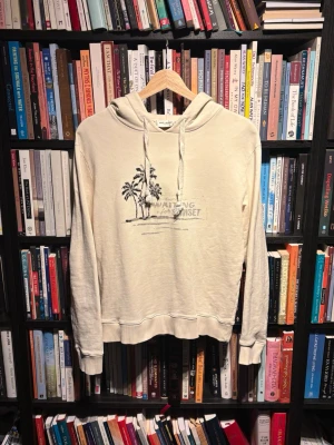 Saint Laurent hoodie - Schysst beige/cremevit SL hoodie i riktigt fint skick. Size S, modellen på bilderna är 173cm och väger 67kg. Inga defekter. Skriv vid funderingar.