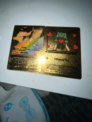 Guldfärgad Pokémon samlarkort - Unikt guldfärgat Pokémon samlarkort med motiv av Charizard och Bulbasaur. Kortet har glansig yta och detaljer i rött, grönt och gult. Perfekt för dig som gillar samlarkort och Pokémon.