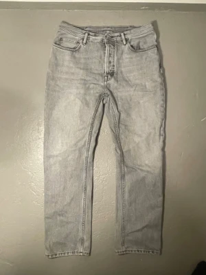 Grå jeans från Acne Studios - Snygga grå jeans från Acne Studios Blå Konst med klassisk femficksdesign och raka ben. Jeansen har en ljusgrå tvätt och är tillverkade i bomull. Perfekta för en stilren och avslappnad look.
