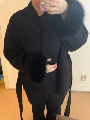 Svart kappa med pälsärmar - Svart kappa från Gina Tricot i nyskick endast använts fåtal gånger. Superfin kappa med päls i ärmarna passar perfekt till våren. Storlek M men passar även mig med storlek S. Kontakta mig vid fler frågor💕