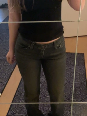 Mörkgrå Levi's jeans - Säljer dessa super fina levi’s jeans i modellen superlow bootcut, storlek 26 längd 32. Färgen heter svart denim men dem ser mer mörkgråa ut och ”washed” vilket man ser bättre på bild 3. Har använt några få gånger.