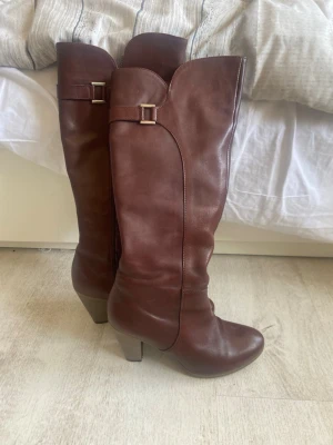 Bruna höga vintage boots med klack - Säljer dessa snygga bruna stövlar i läder med hög klack!💗Super fina men har tyvärr inte kommit till användning eftersom att jag har ett par liknande i svart. Stövlarna har rundad tå, dragkedja på insidan och träklack på 8-9cm. Bara använda vid några få tillfällen och därför ingen slitning på sulan eller klacken. En av stövlarna är skrapad lite på baksidan (se bild 4)