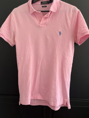 Ralph lauren piké - Säljer denna feta piké från Ralph Lauren. Köpt i butik, går ev att fiska fram kvittot. Säljer för jag har växt ur den. Perfekt till sommaren🙌. Upptäckte nu när jag skulle lägga ut den att den har fått en liten slitning vid loggan, går lätt att lämna in eller fixa själv. Slim fit