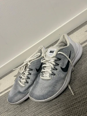 Nike vita mesh sneakers med svart swoosh - Nike sneakers i vitt(vet ej om det är riktig) meshmaterial med svart swoosh på sidan. Skorna har vita snören och en vit sula. Lätta och luftiga med klassisk låg profil och sportig look. Perfekta för dig som gillar stilrena och bekväma sneakers. (Kolla sista bild)