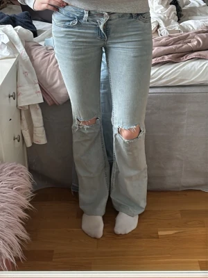 Ljusblå utsvängda jeans - Säljer dess ljusblå bootcut jeans från Nelly. Dem har rosa detalj på bakfickorna. Jag har sytt upp dem lite där nere men det är inget som man tänker på. Använd gärna köp nu