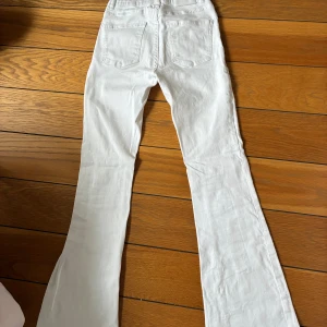 Vita bootcut jeans med låg midja  - Ett par low waist vita jeans.