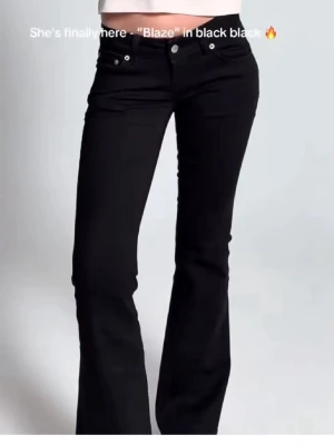 Svarta Blaze jeans med bootcut - Säljer ett par svarta Blaze jeans med låg midja och bootcut. Jeansen har fem fickor, silverfärgade knappar och nitar. Snygg passform som framhäver benen och klassisk svart färg som passar till allt. Perfekta för dig som gillar trendiga och stilrena jeans. Helt nya utan prislapp andvända Ungifär två gånger, sälje då dem inte passade💕