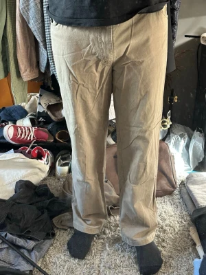 Beige chinos med rak passform - Snygga beige chinos med rak passform och klassisk design. Tillverkade i mjuk bomull som ger en skön känsla hela dagen. Perfekta för dig som vill ha en clean och enkel look. Inga synliga loggor eller detaljer, bara stilrena byxor.