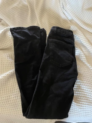 Svarta bootcut jeans - Säljer ett par svarta jeans med bootcut passform och klassiska bakfickor. Jeansen har bälteshällor och är tillverkade i ett mjukt denimtyg💞