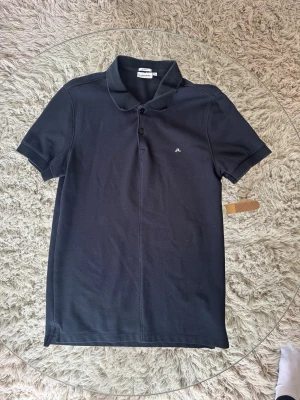 J. Lindeberg Piké - J. Lindeberg Piké i fint skick. Slim fit. Mått (Obs, stretchigt tyg) •Axel-Axel: 40cm •Armhåla-Armhåla: 42cm •Axel-Midja: 62cm