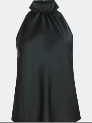 Svart halterneck topp i satin - Snygg svart halterneck topp i glansigt satinmaterial med hög krage. Toppen är ärmlös och har en elegant, lös passform som ger en stilren och modern look, även öppen i ryggen. Perfekt för dig som vill ha något enkelt men ändå trendigt. Använd en gång bara