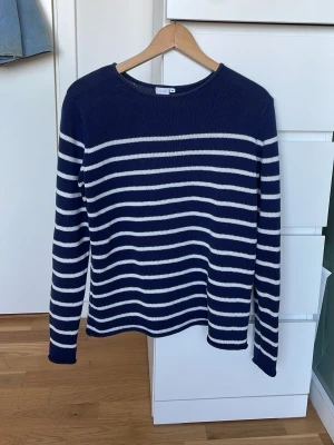 Marinblå och vit randig stickad tröja - Säljer en stilren stickad tröja i marinblått med vita ränder och är jätte skön. Storlek M.