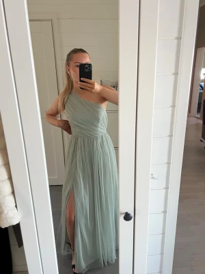 Grön balklänning  - Superfin balklänning från Anaya, jag har använt den 1 gång men köpte den begagnad, fortfarande fint skick.                     Storlek 34/36 skulle jag gissa.                     Jag har även sytt fast ett justerbart gummiband på insidan av midjan så man själv kan anpassa hur tight man vill att den ska sitta. Klänningen har även en slits på framsidan 🤗