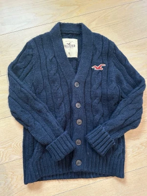 Vintage hollister cardigan - Snygg cardigan från hollister. Plagget är vintage som är eftertraktad. Skicket är dunder då det bara finns lite slitning  men inget marknadsvärt. Storleken är XL men sitter mer som en L. Startpriset är 499 men kan diskuteras😁😁