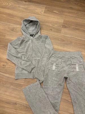 Gråa mjukisbyxor från Juicy Couture - Säljer ett grått mjukisset från Juicy Couture .!⚠️OBS Diamanter trillar av lite då o då, har limmat fast de flesta på tröjan så de bör sitta bra! Därav billigt pris