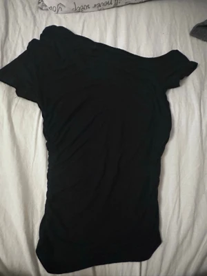 Topp från gina - Säljer denna fina toppen från gina som jag använt kanske 3 gånger. Den har en sne urringning och figursydd