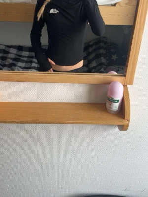 Svart långärmad underställs tröja  - Snygg svart  underställs  tröja  från The North Face med hög krage och tight passform. Perfekt för dig som gillar sportig stil. Diskret logga på bröstet och ryggen. Materialet känns mjukt och stretchigt, vilket gör den bekväm att bära.