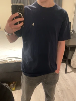 Mörkblå t-shirt från Polo Ralph Lauren - Säljer denna snygga Polo Ralph luaren T-shirt som är lite oversized, då den är lite för stor för mig. Den är i väldigt bra skick då jag inte använt den många gånger alls. Tags finns. Bara höra av sig vid frågor! 