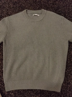 Blue knit sweater - Säljer en stilren grå ribbstickad tröja från Gina Tricot. Tröjan har rund halsringning, långa ärmar och en klassisk, rak passform. Perfekt basplagg till garderoben och enkel att matcha med olika outfits.