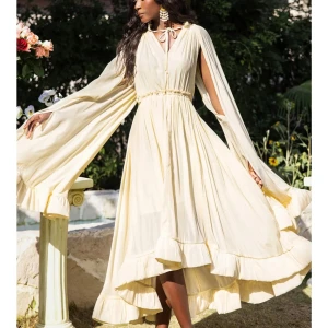 Miss Rosier. Fantastisk långklänning med unik design! Ny!  - Elegant cremefärgad långklänning med volanger och långa vida ärmar. Klänningen är i Tencell tyg, har en v-ringad design med knytning vid halsen och en smickrande midja. Miss Rosier design. Nypris $215.  Helt ny endast provad. Passade tyvärr inte mig.  