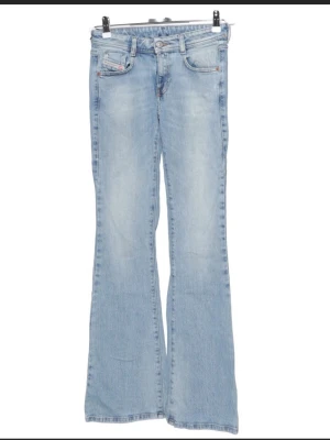 Ljusblå bootcut jeans från Diesel - Säljer ett par ljusblå bootcut jeans från Replay med klassisk femficksmodell och låg midja. Jeansen har utsvängda ben. Väldigt fint skick men har en liten slitning vid midjan (se bild 4), annars som nya! Strl 25 och skulle säga att de sitter som en xs.