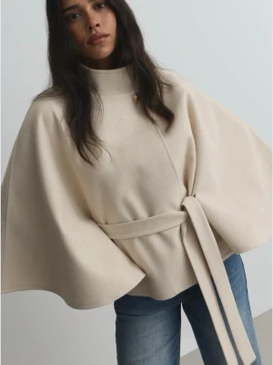 Helt ny beige poncho - Ny med prislapp och förpackning kvar. Stilren beige poncho med krage, dekorativ knapp fram och band i midjan. Onesize, nypris 399kr. 