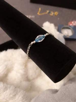 Silver armband med blå  -  armband med en kedja i silverfärg och en avlång blå pärla i mitten, 