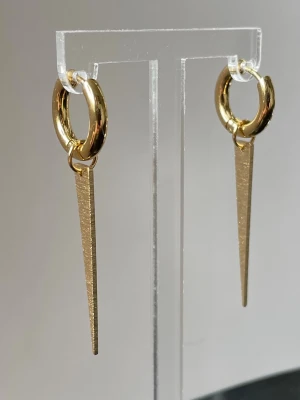 1 par Guldiga hoops örhängen med spetsiga hängen - Snygga örhängen i guld, rostfritt stål/allergi vänliga med runda hoops och långa, spetsiga hängen som ger en edgy look. Perfekta för dig som gillar minimalistisk men ändå statement smycken. 