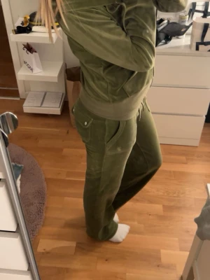 Olivgrön juicy couture sett. - Mysigt olivgrönt juicy couture med matchande ziptröja och byxor. Tröjan har dragkedja och muddar, byxorna har resår och dragsko i midjan samt fickor. Perfekt för en avslappnad och trendig look.Säljer pga aldrig använt. Köpt för 2200.