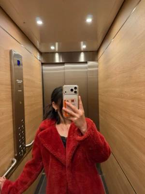 Röd teddyjacka med krage - Säljer en fluffig och oversized röd teddyjacka med bred krage. Jackan har en mjuk och gosig känsla, perfekt för kalla dagar. Inga synliga loggor eller märken. Stängs framtill och har långa ärmar. Passar dig som vill ha en statementjacka i garderoben.