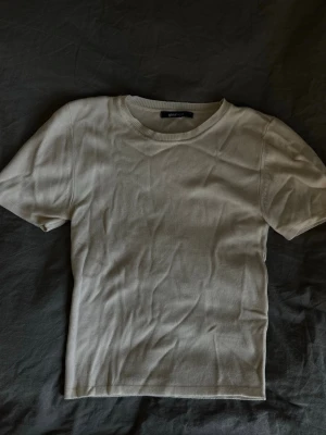 Ljus beige ribbad t-shirt från Gina Tricot - En basic ribbad t-shirt från Gina Tricot i storlek S. T-shirten har korta ärmar, rund halsringning och är gjord i mjuk bomull. 
