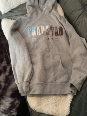Trapstar hoodie  - Säljer nu en grå trapstar hoodie, använt få gånger och är som ny. Storlek m, säljer den pga att den inte kommer till användning. Hör Järna av dig om frågor eller vill ha fler bilder.