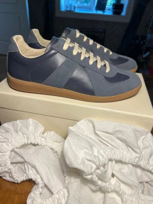 Maison margiela blå - Maison marigela skor ÄKTA KVITTO FINNS. Nypris 6600. Mitt pris 3299. Kan möjligtvis gå ner i pris. Äktenhetskap kan visas genom att skanna undersidan av skon.