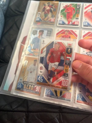 Match Attax fotbollskort Erling Haaland - Samlarfotbollskort från Topps Match Attax-serien, UEFA Nations League. Kortet visar Erling Haaland i Norges landslagströja, med färgerna röd, blå och vit samt flera stats och grafik på framsidan. Baksidan har norsk flagga och text om serien.