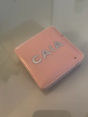 CAIA krämrouge i pink lemonade - Knappt använd. Säljer ett krämrouge från CAIA i en snygg persikoton. Kommer i en stilren, ljusrosa fyrkantig dosa med spegel i locket. Perfekt för att ge kinderna en naturlig glow och fräsch färg. Enkel att applicera tack vare den krämiga formulan.