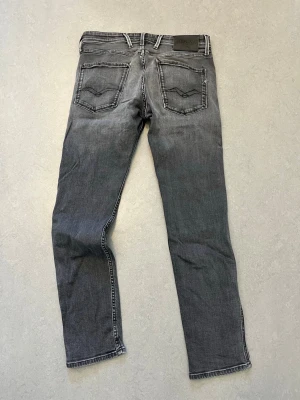 Replay - grå - slimfit - W31 L30 - Snygga grå replay jeans i slim fit-modell med diskreta slitningar och tvättade detaljer. Klassisk femficksdesign och raka ben. Riktigt schysst skick på dem. Pris är förhandlingsbart. W31 L30