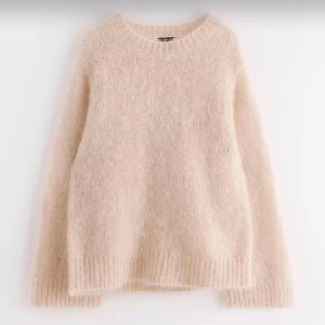 stickad tröja i mohair blandning - Mysig beige stickad tröja med rund hals och långa ärmar. Tröjan har en fluffig, mjuk struktur och ribbstickade muddar vid ärmslut och nederkant. Perfekt för kalla dagar och enkel att matcha med olika outfits. I alpacka / mohair blandning från Lindex nypris 1499kr, knappt använd💓💓 storlek m passar bra lite oversized på mig som har s, skriv för fler bilder!
