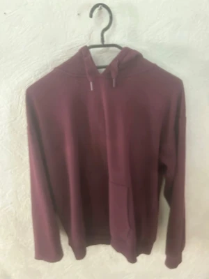 Vinröd hoodie från Gina Tricot - Säljer en vinröd hoodie från Gina Tricot med huva och dragsko. Hoodien har en klassisk känguruficka framtill och långa ärmar. Perfekt för dig som gillar en enkel och stilren look. Materialet känns mjukt och bekvämt.