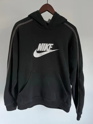 Nike Sportswear/Fleece Hoodie - Nike Sportswear/Fleece Hoodie Storlek: S Passform: Regular Fit Krage: Fast huva med dragsko Material: S Mått: Bröstvidd 110 cm, längd 56 cm, axel 48 cm Skick: Huvtröjan är i ett väldigt fint skick med en defekt/prick som syns på bild Nypris cirka: 800 kr