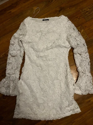 Vit blommönstrig klänning - Fin vit klänning från Gina tricot i storlek M. Använd två gånger.