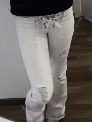 Jens med snöring ifrån Gina  - Dom är i stolek xss tall men har själv sytt upp dom i benen. Dom är parfekt i längd på mig som är 155 och vanligt viss har stolek 158 Säljer ett par ljusa jeans med slitningar och hål på benen. De har raka ben och en avslappnad passform som är perfekt för en cool och trendig look. Materialet är denim och jeansen har klassiska fickor både fram och bak.