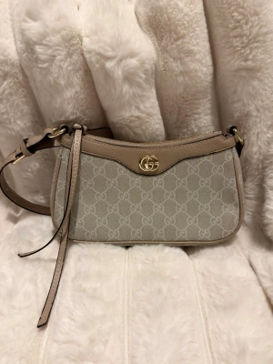 Beige grå axelväska - Snygg beige axelväska. Perfekt storlek för det viktigaste och en stilren design som lyfter varje outfit.