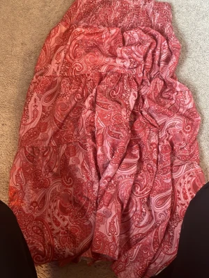 Mönstrad kjol - En superfin mönstrad kjol rosa/röd. Använd fåtal gånger och är i super bra skick