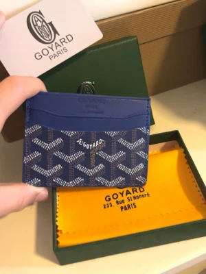 Blå plånbok kortfodral från Goy4ard - Snyggt blått kortfodral från Goy4ard med det klassiska vita och gråa Goy4ard-mönstret. Tillverkat i exklusivt läder och canvas, har flera fack för kort och är perfekt för dig som vill ha en stilren och lyxig accessoar. Kommer med originalask och dustbag.
