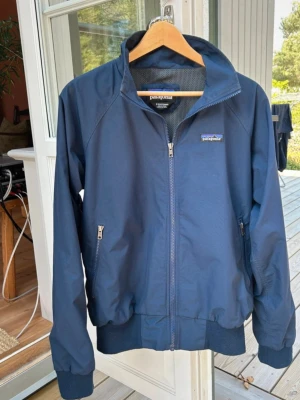 Mörkblå vindjacka från Patagonia - Snygg mörkblå vindjacka från Patagonia. Storlek S i väldigt bra skick - som ny. Säljer pga för liten. Hör av dig vid intresse eller frågor.